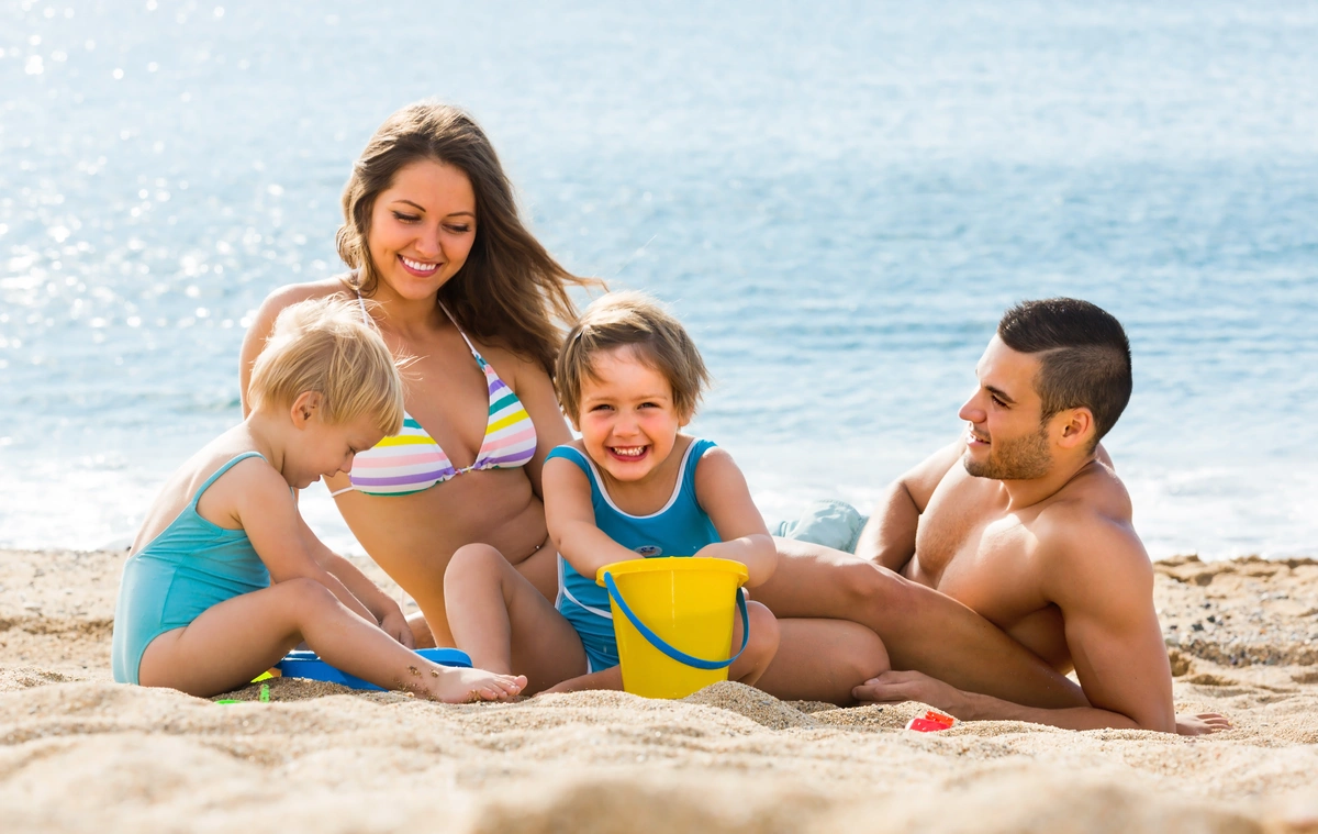 A young happy family with two kids having a vacation on the beach